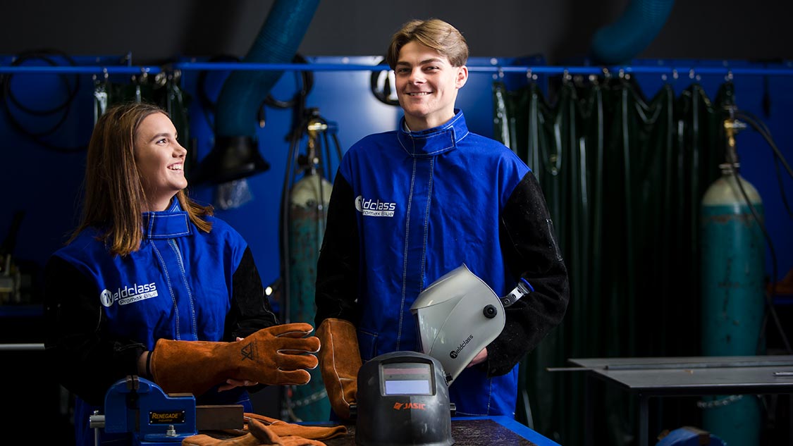Two students wearing welding PPE