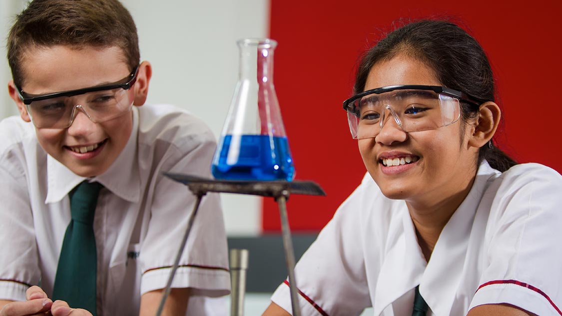 Students in science using a bunsen burner