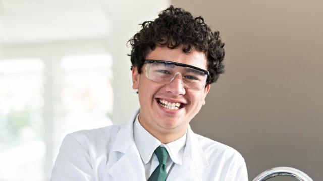 A student smiling wearing PPE