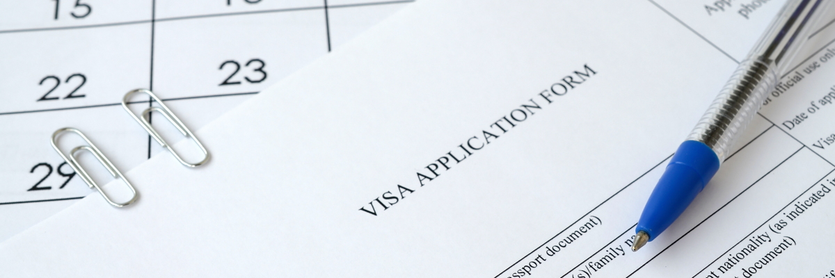 Photo of a visa application form and a pen